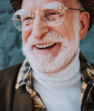 Smiling senior man with beard and glasses