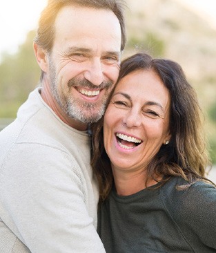 Couple smiling after dental implant post-op instructions in Rio Rancho