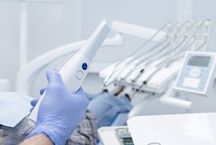 Gloved hand holding device used to capture digital dental impressions
