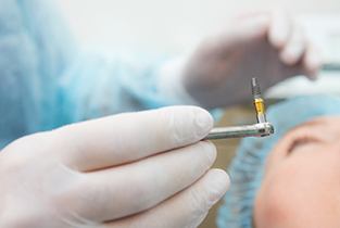 dentist placing implant in patient’s mouth 