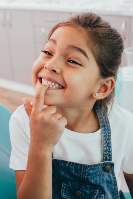 Child pointing to smile after children's dentistry visit