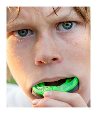 Teen placing a a green athletic mouthguard