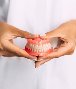 closeup of dentist holding dentures