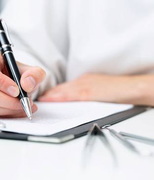 Dentist sitting at desk, taking notes