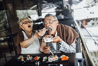 mature couple eating sushi   