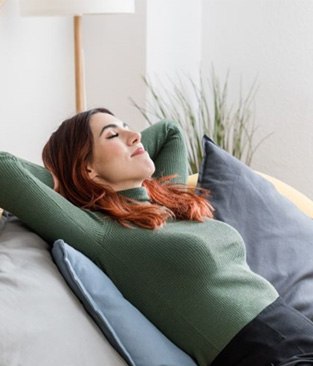 Woman reclining on sofa, relaxing at home