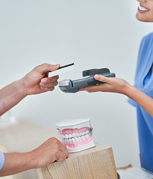 a patient paying for Invisalign treatment