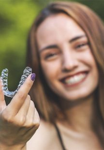 Dentist holding model of dental implant in Memorial