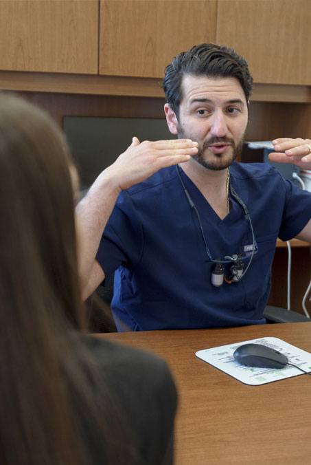 Smiling man in dental chair after replacing missing teeth