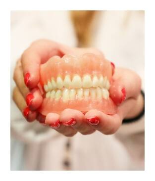Hands holding a full denture