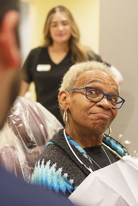 Woman pointing to inflamed soft tissue after gum disease treatment