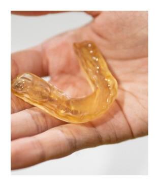 Hand holding a nightguard for bruxism