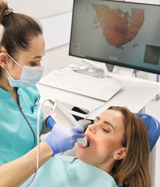 Dental team member taking digital impression of patient&rsquo;s teeth