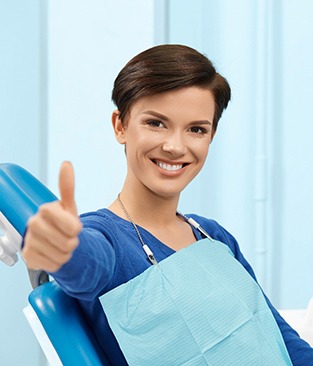 Happy dental patient making thumbs-up gesture