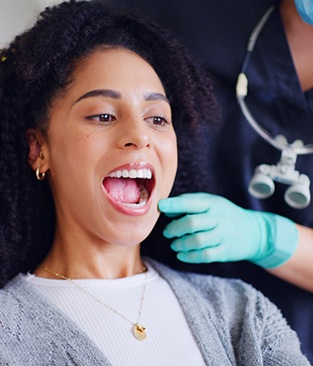 Dental patient looking at her teeth in mirror