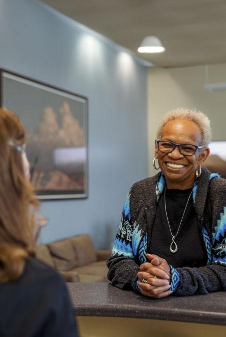 Woman in smiling while receiving exceptional dental services Rio Rancho New Mexico