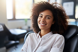 Woman in white shirt smiling while sitting in black chair