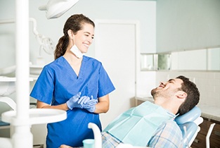 Woman with white teeth smiling at reflection in mirror