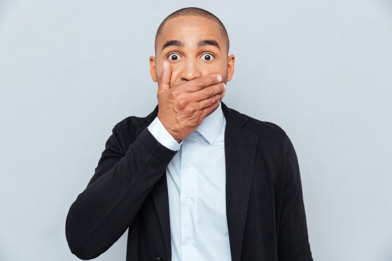 A handsome African man covering his mouth