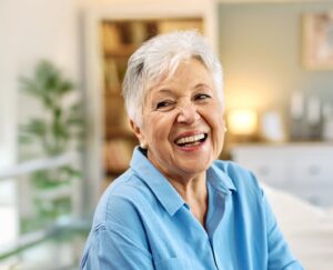 Older woman in blue blouse wearing dentures